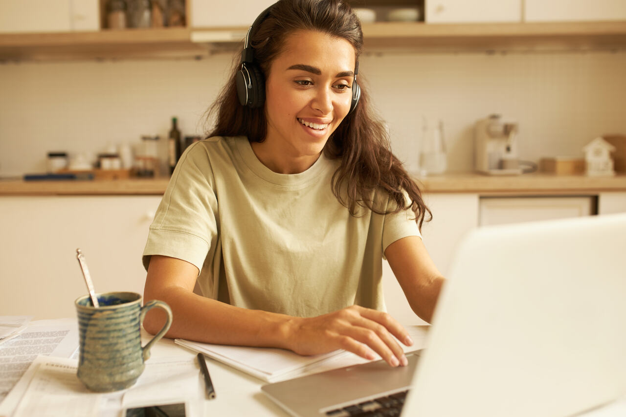 Jovem estuda no notebook usando fones de ouvido 