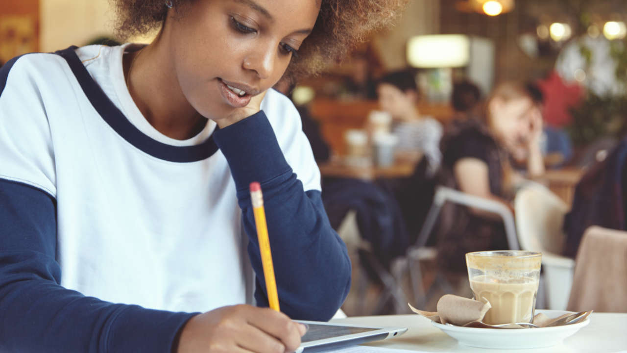 Jovem negra escrevendo redação