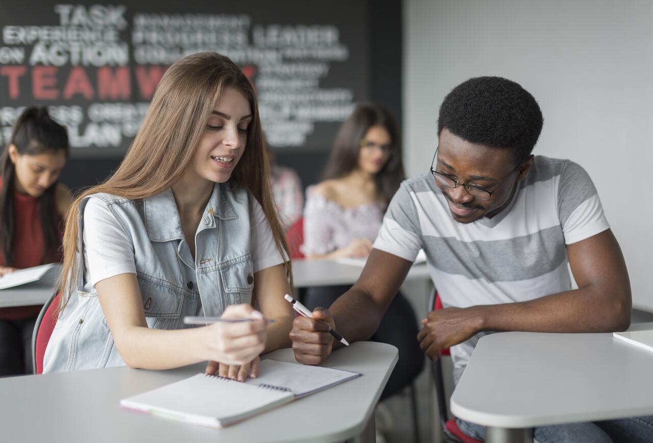 Adolescentes em uma sala de aula estudando 