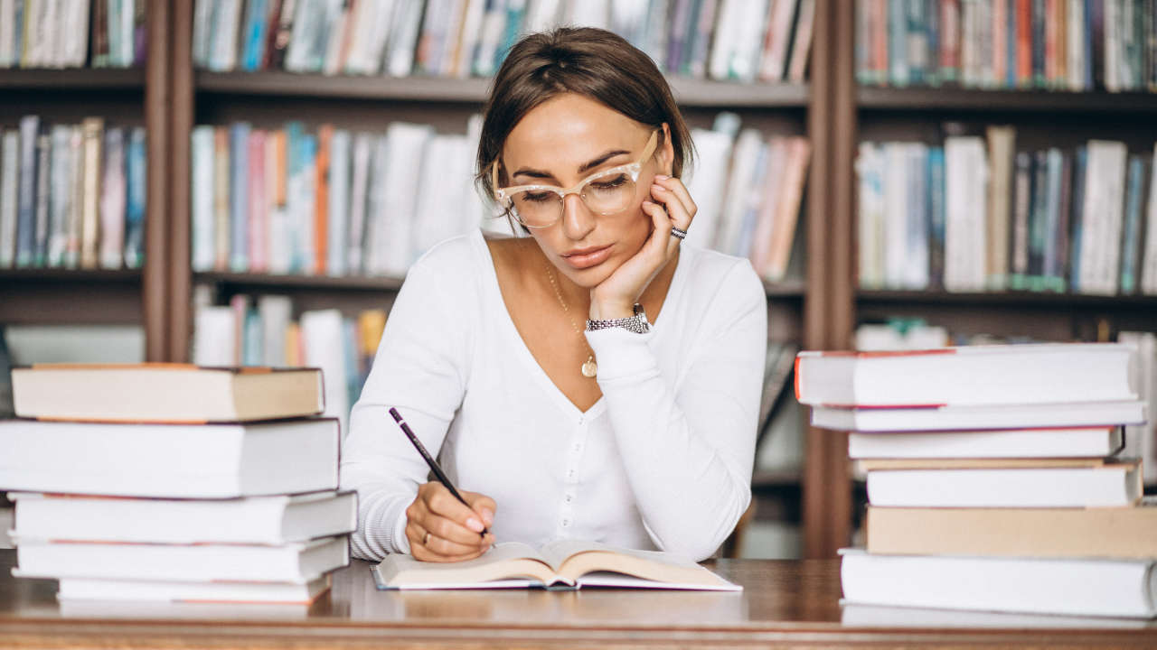 Mulher jovem estudando em biblioteca