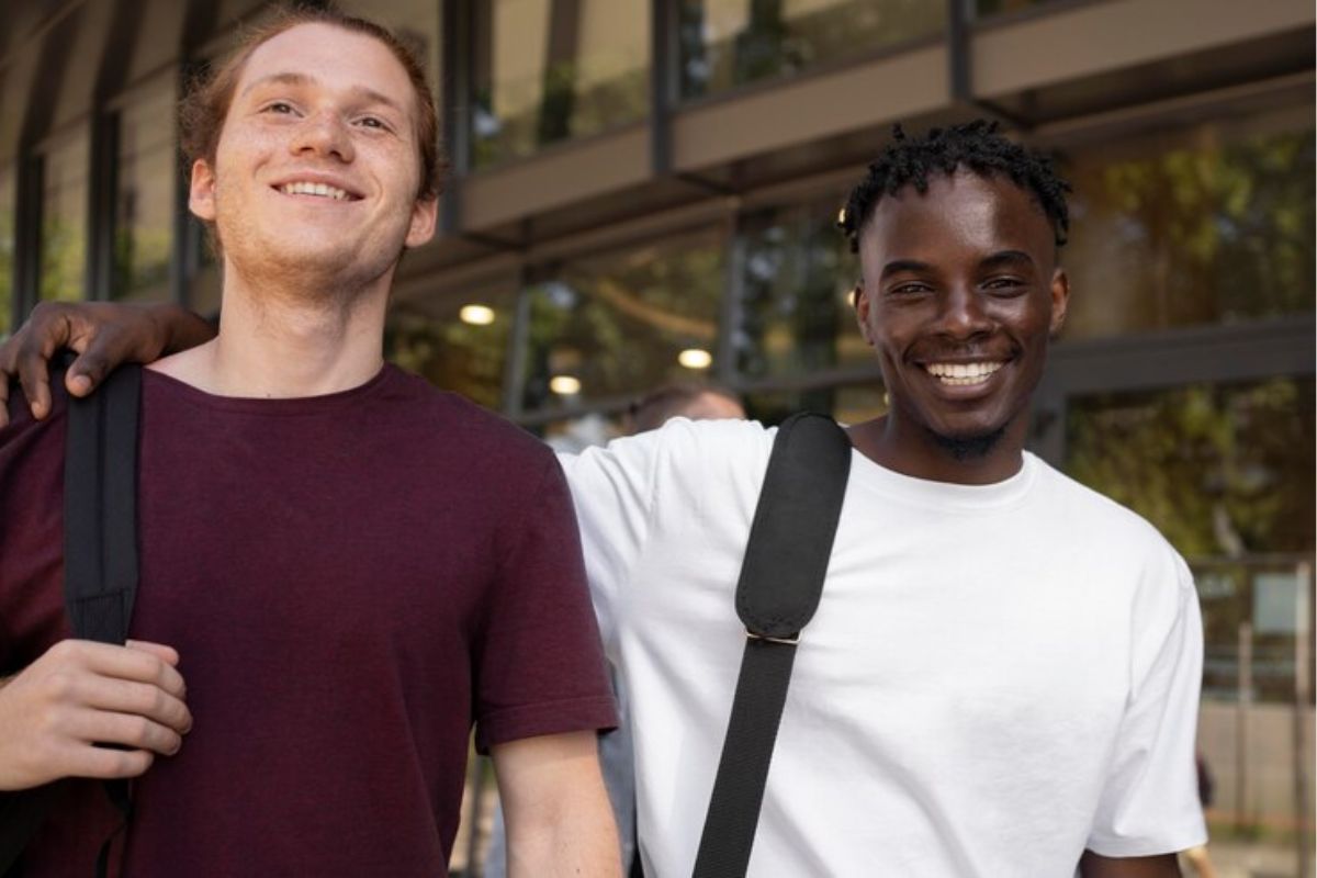 Dois estudantes animados sorrindo antes de fazer a Inscrição UERJ 2025 Doutorado. Um amigo passa o braço por cima do ombro do outro