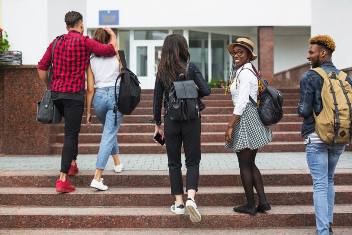 5 estudantes subindo a escadaria de uma universidade para fazer a Inscrição UERJ 2025 Doutorado.jpg