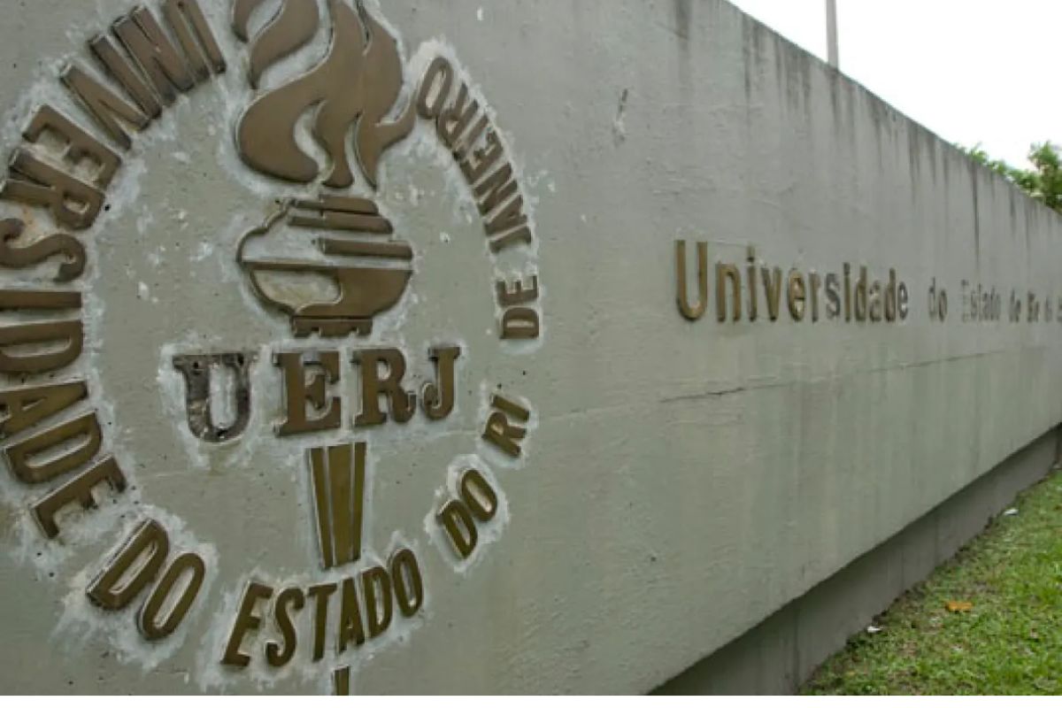 Entrada da UERJ onde é possível ver o nome e abreviação da instituição no muro