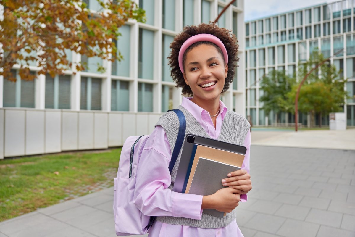 Jovem estudante segurando livros no campus