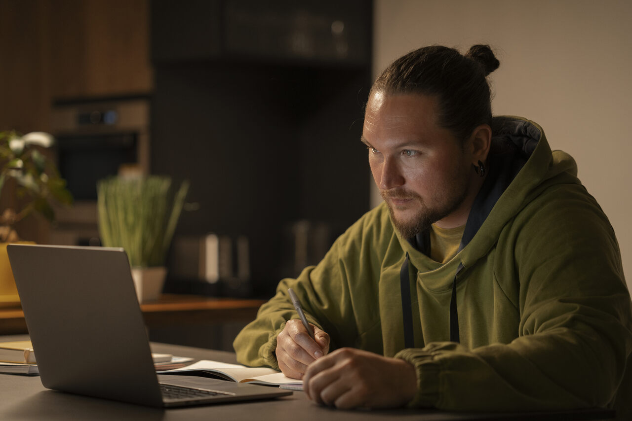 Homem adulto estudando a noite em seu notebook 