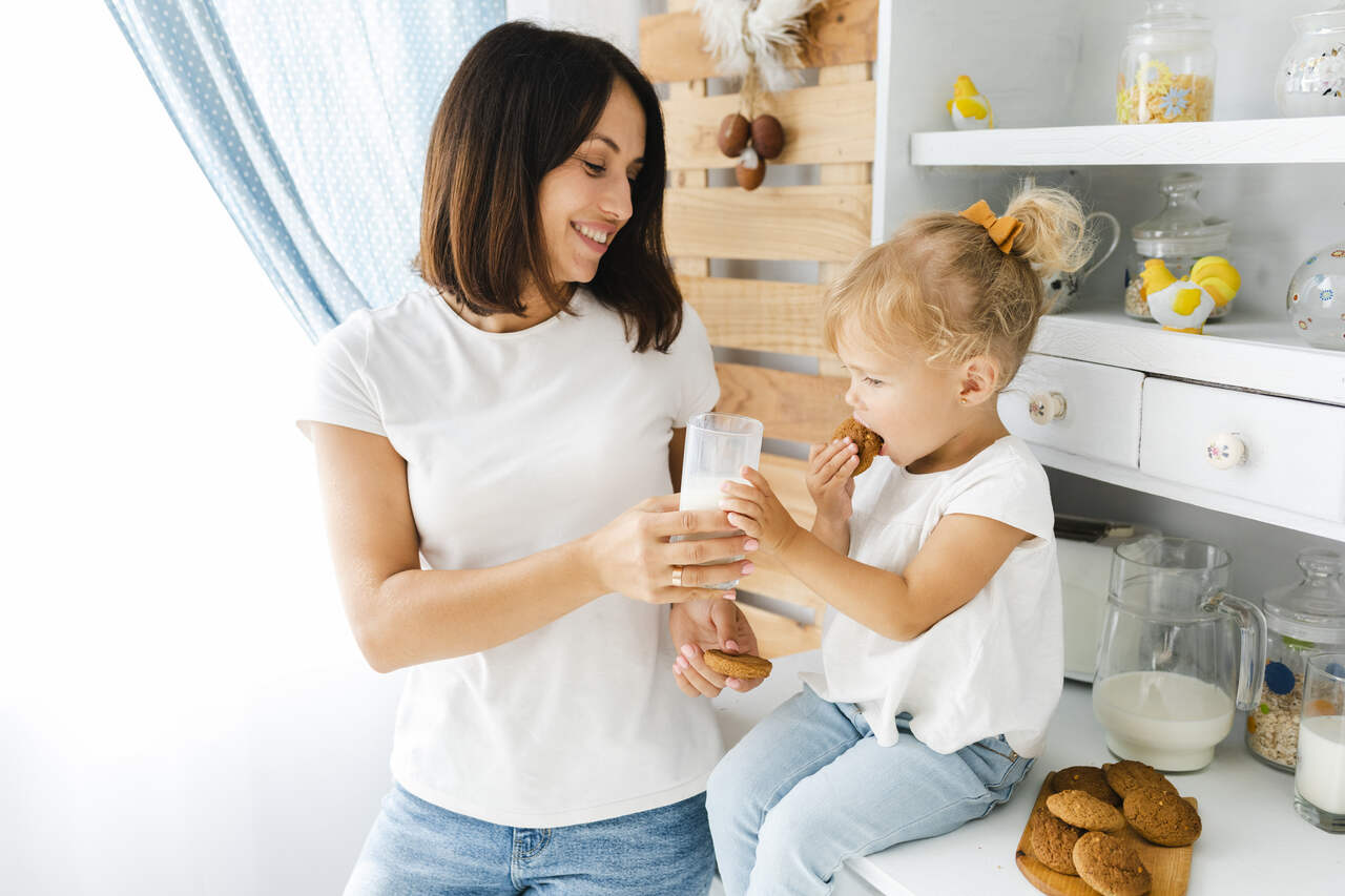 Mãe da leite e biscoitos para a filha 