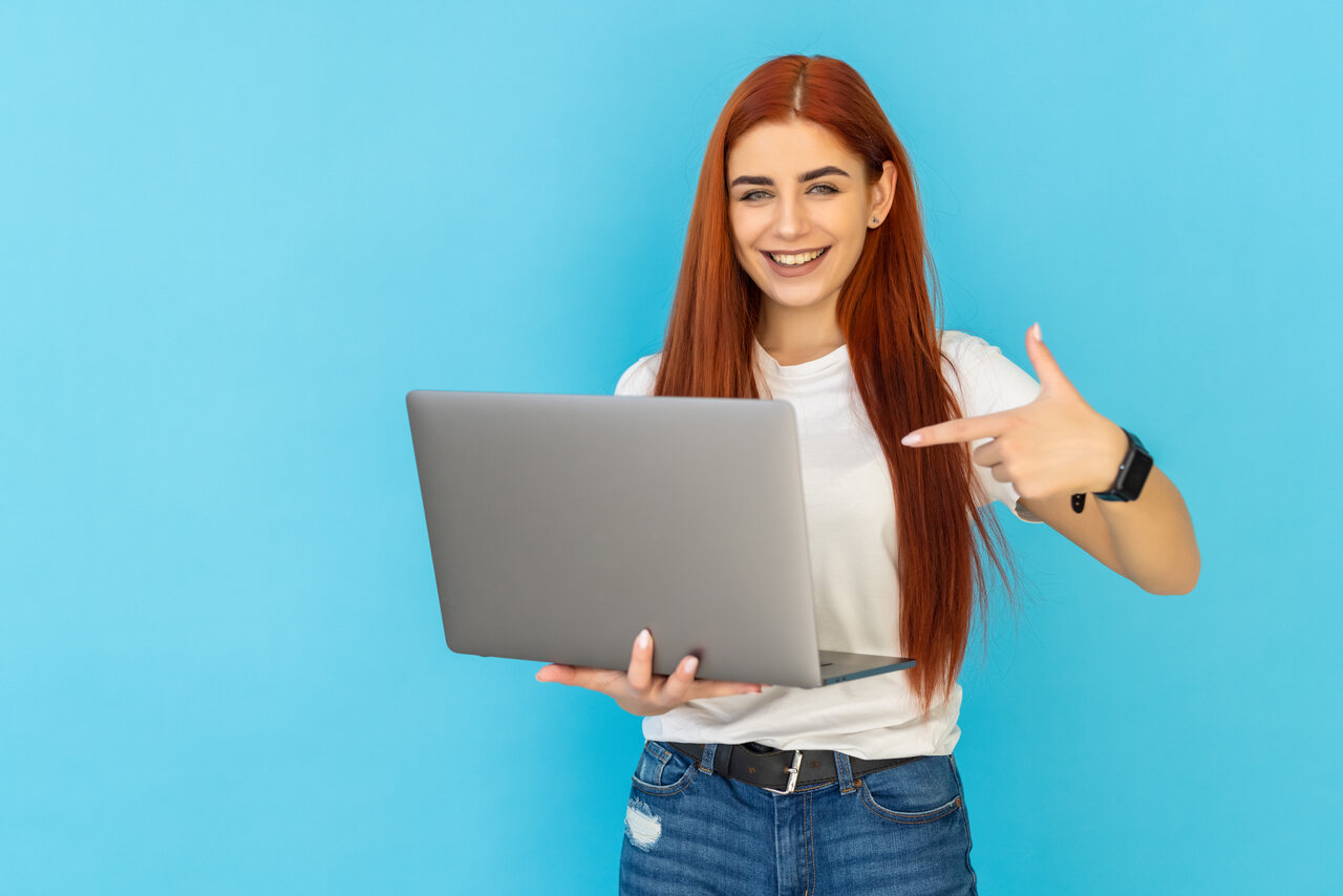 Jovem aponta para notebook em sua mão 