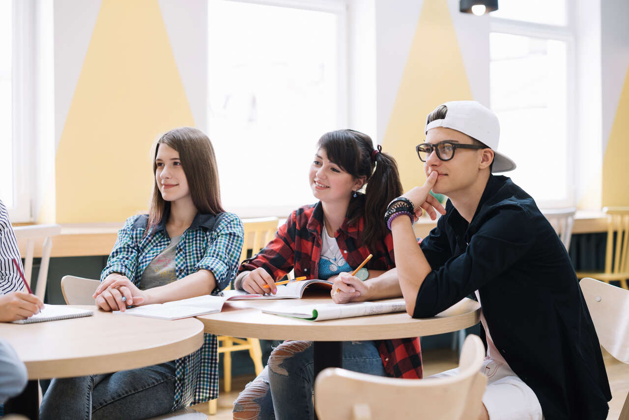 Adolescentes assistem a aula concentrados 